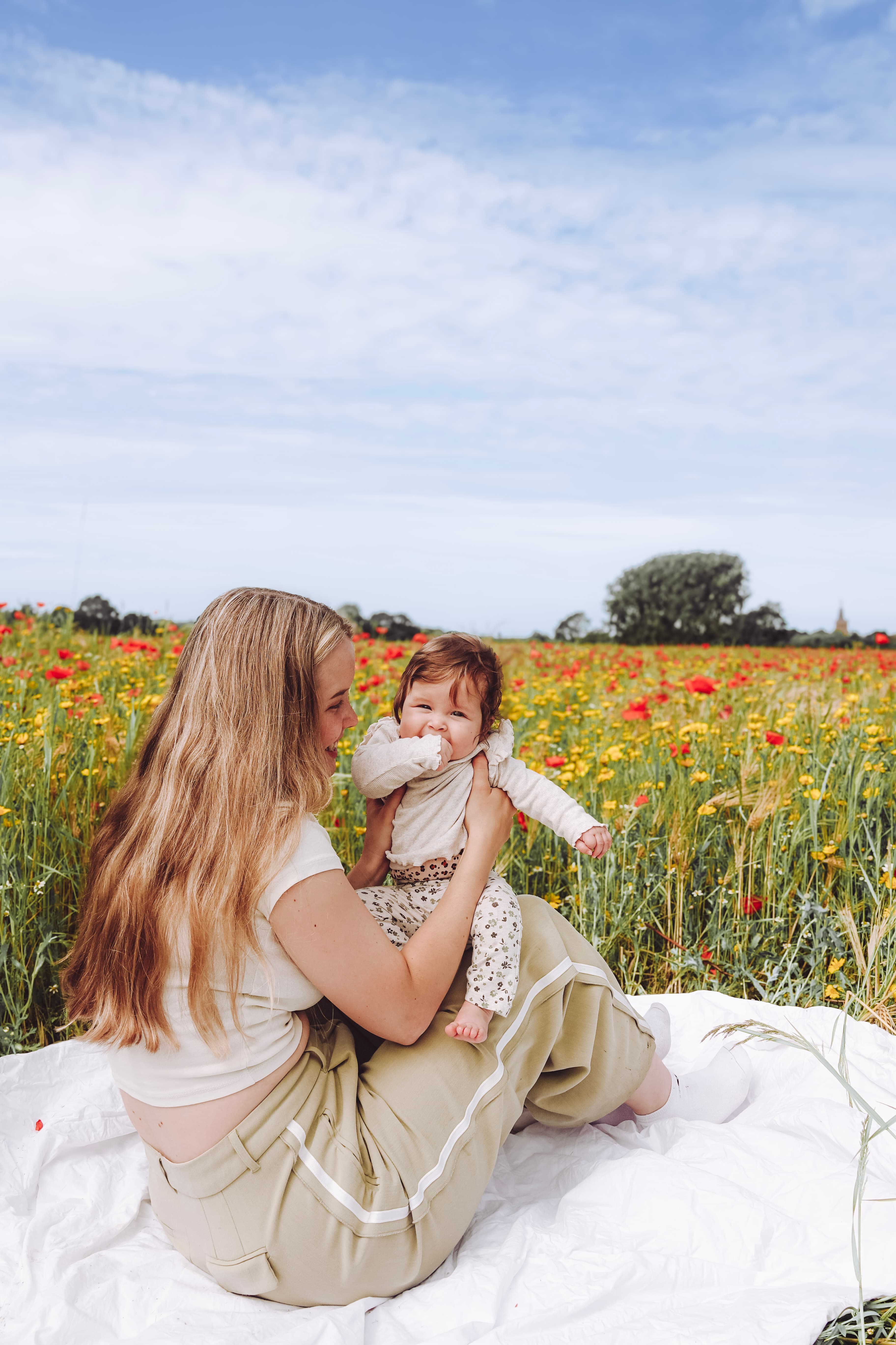 Moeder en baby in een weelderig bloemenveld