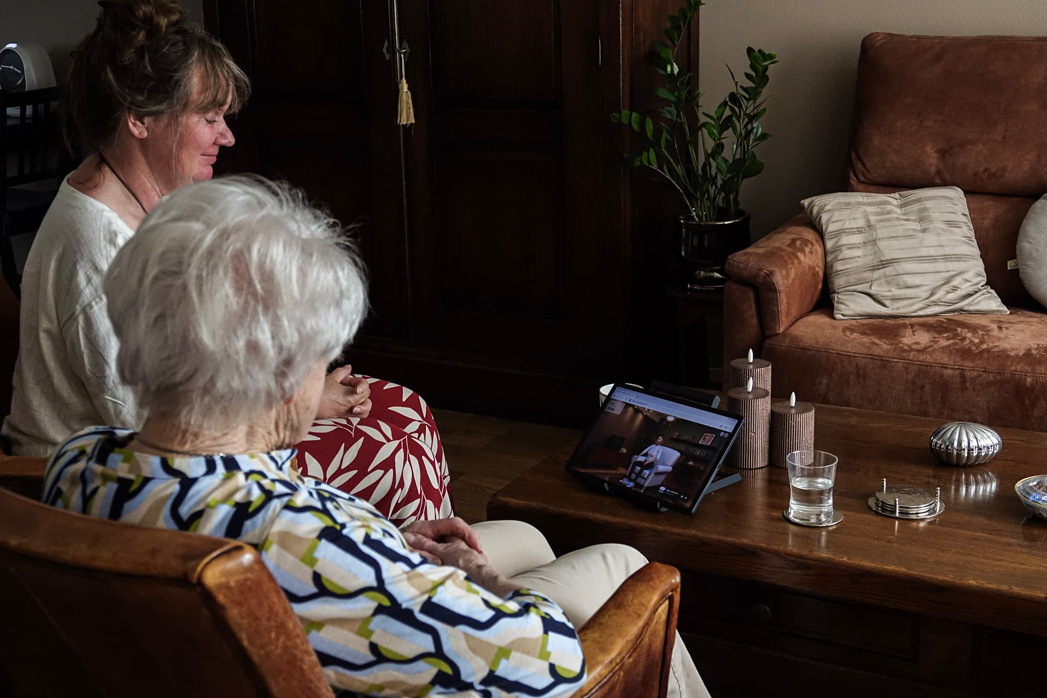Oma en kleinkind lachen samen naar een herinnering op een tablet